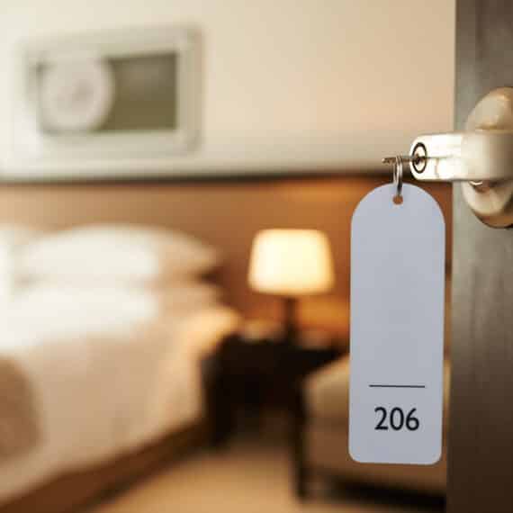 Ouverture de la porte d'une chambre d'hôtel avec la clé dans la serrure